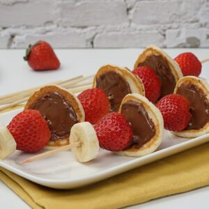 Two skewers with pancakes, strawberries, and bananas